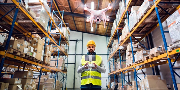 Worker uses a drone to navigate warehouse